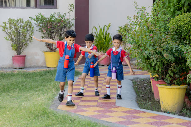 Happy indian school kids running outside the primary school. Education concept.